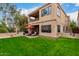 Back exterior view of the home, featuring a patio, balcony, and lush green lawn at 7525 E Gainey Ranch Rd # 110, Scottsdale, AZ 85258