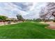 View of a meticulously maintained golf course with lush green grass and mature trees under a cloudy sky at 7525 E Gainey Ranch Rd # 110, Scottsdale, AZ 85258