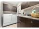 Practical laundry room with modern appliances and cabinetry, sink and ample counter space at 7525 E Gainey Ranch Rd # 110, Scottsdale, AZ 85258