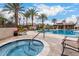 Resort-style community pool and hot tub surrounded by palm trees, lounge chairs, and lush landscaping at 7525 E Gainey Ranch Rd # 110, Scottsdale, AZ 85258