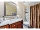 Well-lit bathroom with marble countertop vanity, framed mirror, and shower over tub at 8431 W Planada Ln, Peoria, AZ 85383