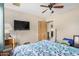 Bedroom with ceiling fan, wood floor, and TV mounted on wall at 8431 W Planada Ln, Peoria, AZ 85383