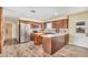 This kitchen features dark wood cabinets, stainless steel appliances, and a kitchen island with a light countertop at 8431 W Planada Ln, Peoria, AZ 85383