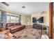 Cozy living room featuring wood floors, a leather sofa, and a large window at 8431 W Planada Ln, Peoria, AZ 85383