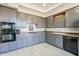 Well-lit kitchen featuring ample gray cabinetry, stainless steel appliances, and modern countertops at 9113 N 116Th Way, Scottsdale, AZ 85259