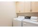 Bright laundry room with front loading washer and dryer, plus above cabinet storage at 9113 N 116Th Way, Scottsdale, AZ 85259