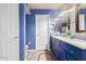 Modern bathroom featuring bright blue walls, granite countertop, and lots of storage at 9116 W Acoma Dr, Peoria, AZ 85381