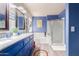 Modern bathroom featuring bright blue walls, soaking tub, granite countertop, and glass shower at 9116 W Acoma Dr, Peoria, AZ 85381