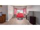 Cozy bedroom with a red couch and bright pink curtains, and stylish wood flooring at 9116 W Acoma Dr, Peoria, AZ 85381