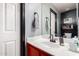Bright bathroom featuring a white sink, orange vanity, and a large mirror at 11234 W Roma Ave, Phoenix, AZ 85037