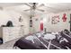 Spacious bedroom with a large dresser, modern ceiling fan, and unique musical decorations at 11234 W Roma Ave, Phoenix, AZ 85037