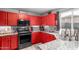 Bright kitchen featuring vibrant red cabinetry, granite countertops, and stainless steel appliances at 11234 W Roma Ave, Phoenix, AZ 85037