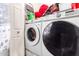 This laundry room has a modern washer and dryer, and built-in shelving for storage at 11234 W Roma Ave, Phoenix, AZ 85037
