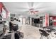 Open-concept living room with neutral tile flooring, a staircase, and a media center at 11234 W Roma Ave, Phoenix, AZ 85037