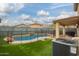 Backyard with sparkling pool, patio, and artificial turf at 11234 W Roma Ave, Phoenix, AZ 85037