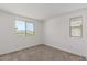Bedroom features neutral carpet, clean white walls, and a view from two large windows at 15610 S 181St Dr, Goodyear, AZ 85338
