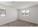 The bedroom boasts neutral carpet, clean white walls, and a view from two large windows at 15610 S 181St Dr, Goodyear, AZ 85338