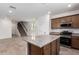 Modern kitchen with stainless steel appliances, granite countertops, and an island, open to the living area at 15610 S 181St Dr, Goodyear, AZ 85338