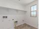 The laundry room offers ample shelving and natural light from the window at 15610 S 181St Dr, Goodyear, AZ 85338