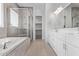 Modern bathroom featuring a soaking tub, glass-enclosed shower, and double vanity at 15846 W Bronco Trl, Surprise, AZ 85387