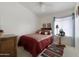 Comfortable bedroom with a ceiling fan features a decorative bed, carpet and window with sheer curtains at 16424 N 1St Dr, Phoenix, AZ 85023