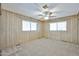 Spacious bedroom featuring neutral carpet, ample lighting from a ceiling fan and natural light from two windows at 17244 N 66Th Ln, Glendale, AZ 85308