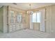 An open dining room with built-in china cabinet, modern chandelier, and large windows for natural light at 17244 N 66Th Ln, Glendale, AZ 85308