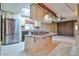 Updated kitchen with stainless steel refrigerator, island cooktop, and adjacent living spaces at 17244 N 66Th Ln, Glendale, AZ 85308