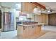 Modern kitchen featuring stainless steel appliances, an island with cooktop and a skylight at 17244 N 66Th Ln, Glendale, AZ 85308