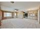 An open living area featuring fresh carpeting, a ceiling fan, and a doorway to a central kitchen at 17244 N 66Th Ln, Glendale, AZ 85308