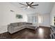 Well-lit living room with plantation shutters, grey sofa and hardwood floors at 17631 N 42Nd Dr, Glendale, AZ 85308