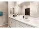 Bathroom showcasing a large mirror, modern sink, and white cabinets at 17845 W Red Fox Rd, Surprise, AZ 85387
