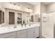 Modern bathroom featuring double sinks, and a glass-enclosed shower at 17845 W Red Fox Rd, Surprise, AZ 85387