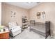 Cozy Bedroom with a crib, armchair, and decorative accents at 17845 W Red Fox Rd, Surprise, AZ 85387