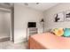 Cozy bedroom with salmon bedding, TV, dresser, and neutral walls at 17845 W Red Fox Rd, Surprise, AZ 85387