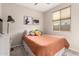 Comfortable bedroom with salmon bedding, gray carpet, and window view at 17845 W Red Fox Rd, Surprise, AZ 85387
