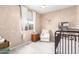 Neutral Bedroom with a white armchair, crib, and natural light at 17845 W Red Fox Rd, Surprise, AZ 85387