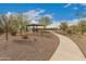 Sidewalk leading to a community gazebo with picnic tables and desert landscaping at 17845 W Red Fox Rd, Surprise, AZ 85387