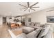 Open concept living room with modern fan, neutral colors, and lots of natural light at 17845 W Red Fox Rd, Surprise, AZ 85387
