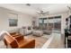 Stylish living room featuring a large sectional sofa and access to the patio at 17845 W Red Fox Rd, Surprise, AZ 85387