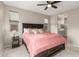 Spacious primary bedroom with a ceiling fan, carpet, and access to the bathroom at 17845 W Red Fox Rd, Surprise, AZ 85387