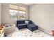 Playroom with blue sofa, playroom rug, and natural light from the window at 17845 W Red Fox Rd, Surprise, AZ 85387