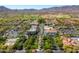 Wide aerial view of a community with well-maintained streets, lush trees, and the backdrop of scenic mountains at 21008 W Cora Vis, Buckeye, AZ 85396