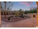 Beautifully landscaped backyard with a fireplace, palm trees, and manicured shrubs at 21008 W Cora Vis, Buckeye, AZ 85396
