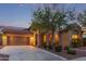Charming single-Gathering home featuring a two-car garage and well-manicured landscaping at dusk at 21008 W Cora Vis, Buckeye, AZ 85396