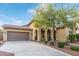 Charming single-story home with arched entryway, desert landscaping, three car garage and a paved driveway at 21008 W Cora Vis, Buckeye, AZ 85396