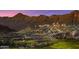 Luxury home on a hilltop overlooking a lush green golf course and rugged mountains at 21008 W Cora Vis, Buckeye, AZ 85396