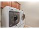 Laundry room features a Maytag washer and dryer set with overhead cabinets for storage at 21008 W Cora Vis, Buckeye, AZ 85396