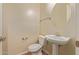 This half bathroom features a pedestal sink, a decorative mirror, and neutral wall paint at 21008 W Cora Vis, Buckeye, AZ 85396