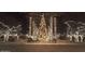 Nighttime street view featuring dazzling holiday lights adorning palm trees and landscaping, creating a festive atmosphere at 21008 W Cora Vis, Buckeye, AZ 85396